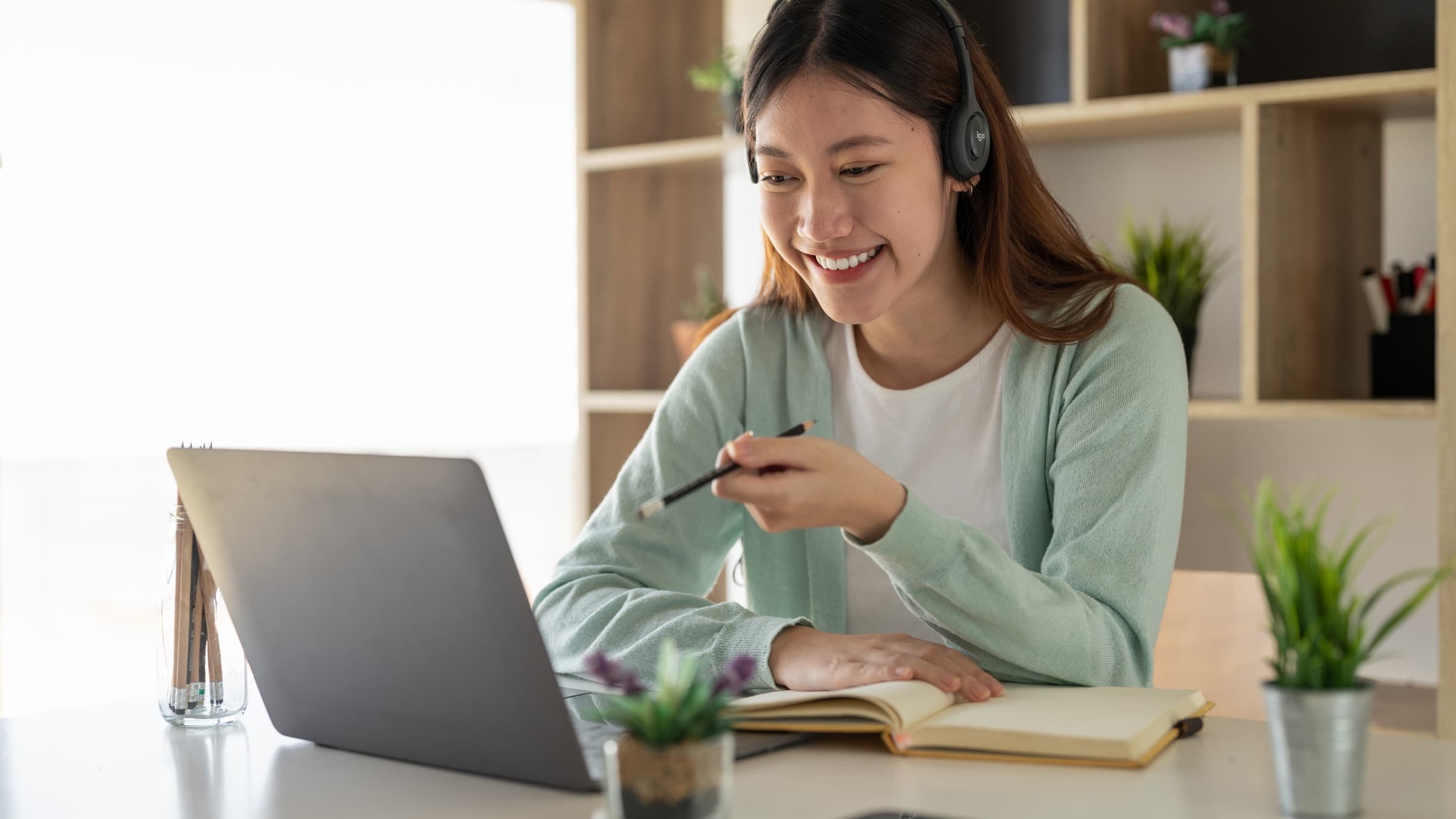 Alumna con auriculares siguiendo una clase en línea frente a su portátil