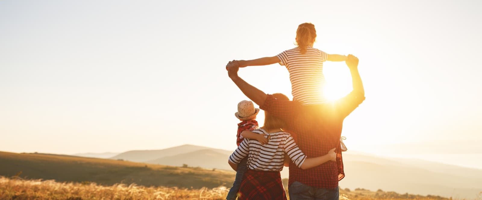 Familia abrazada mirando el atardecer