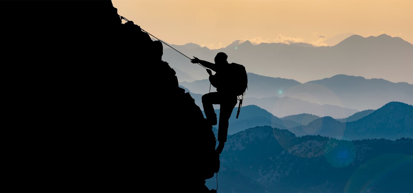 Silueta de un escalador en la montaña al atardecer