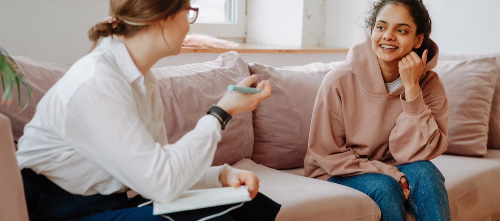 Dos jóvenes conversando en un sofá