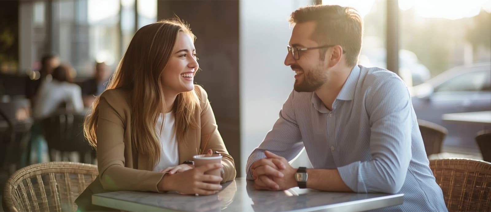 Pareja conversando y sonriendo en una terraza