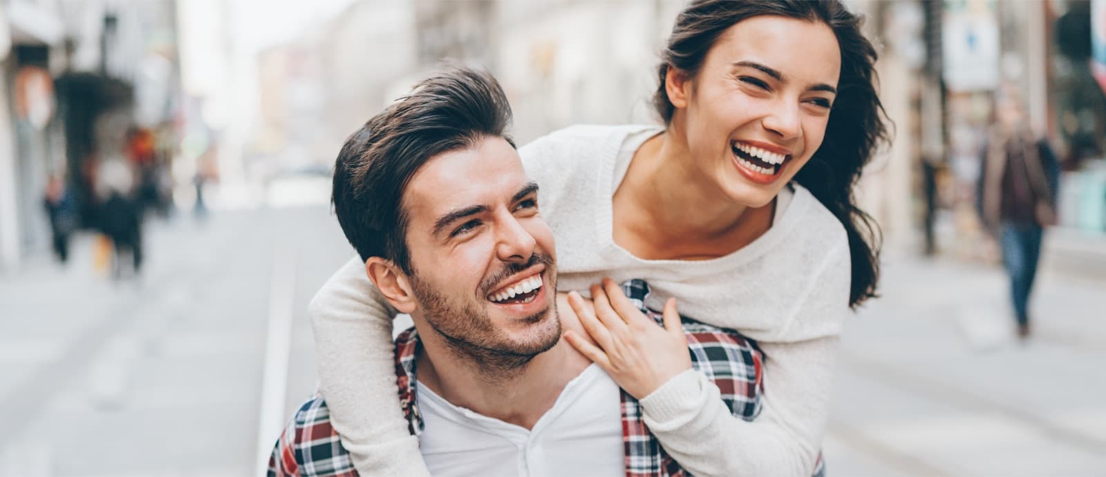 Pareja abrazándose sonriendo en ambiente urbano