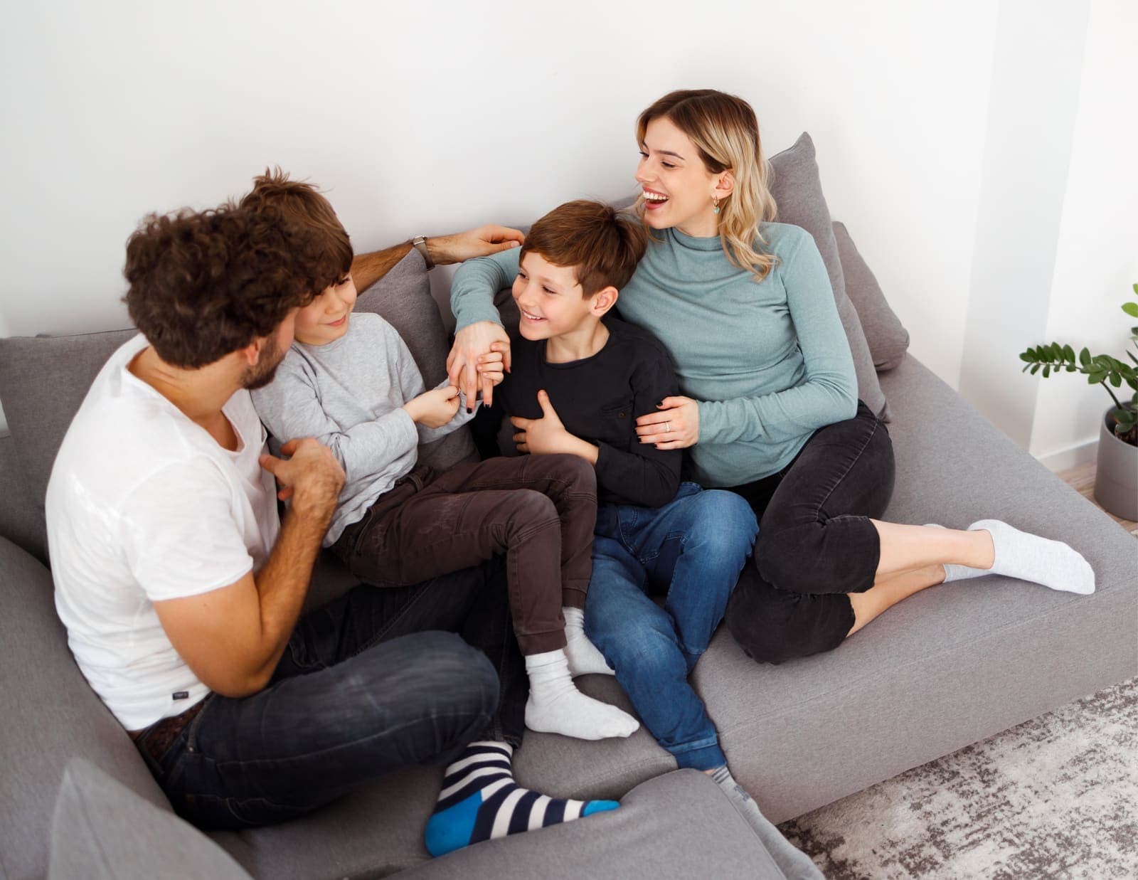 Familia conversando y riendo en el sofá de casa